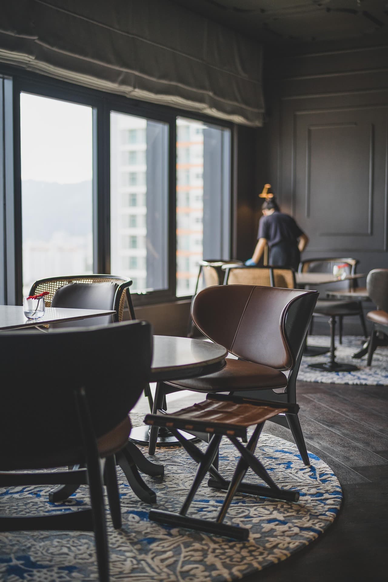 Upscale restaurant lounge with leather seating being maintained by a Space Care team member