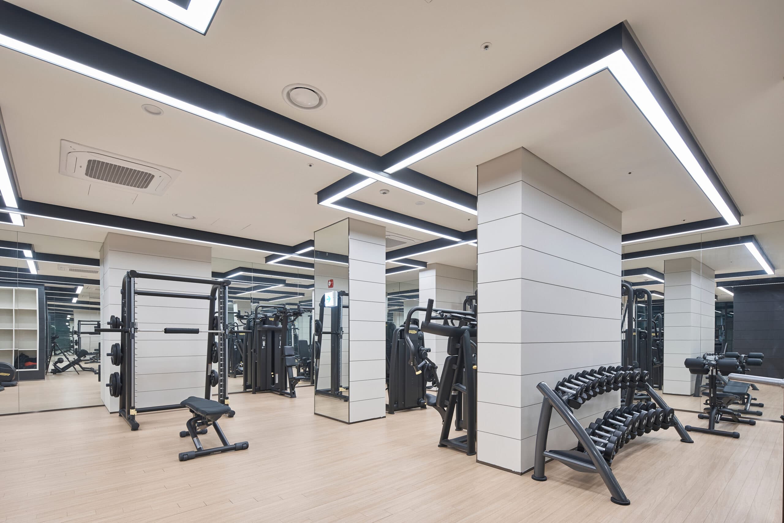 Clean modern gym weight room with equipment and mirrors maintained by Space Care