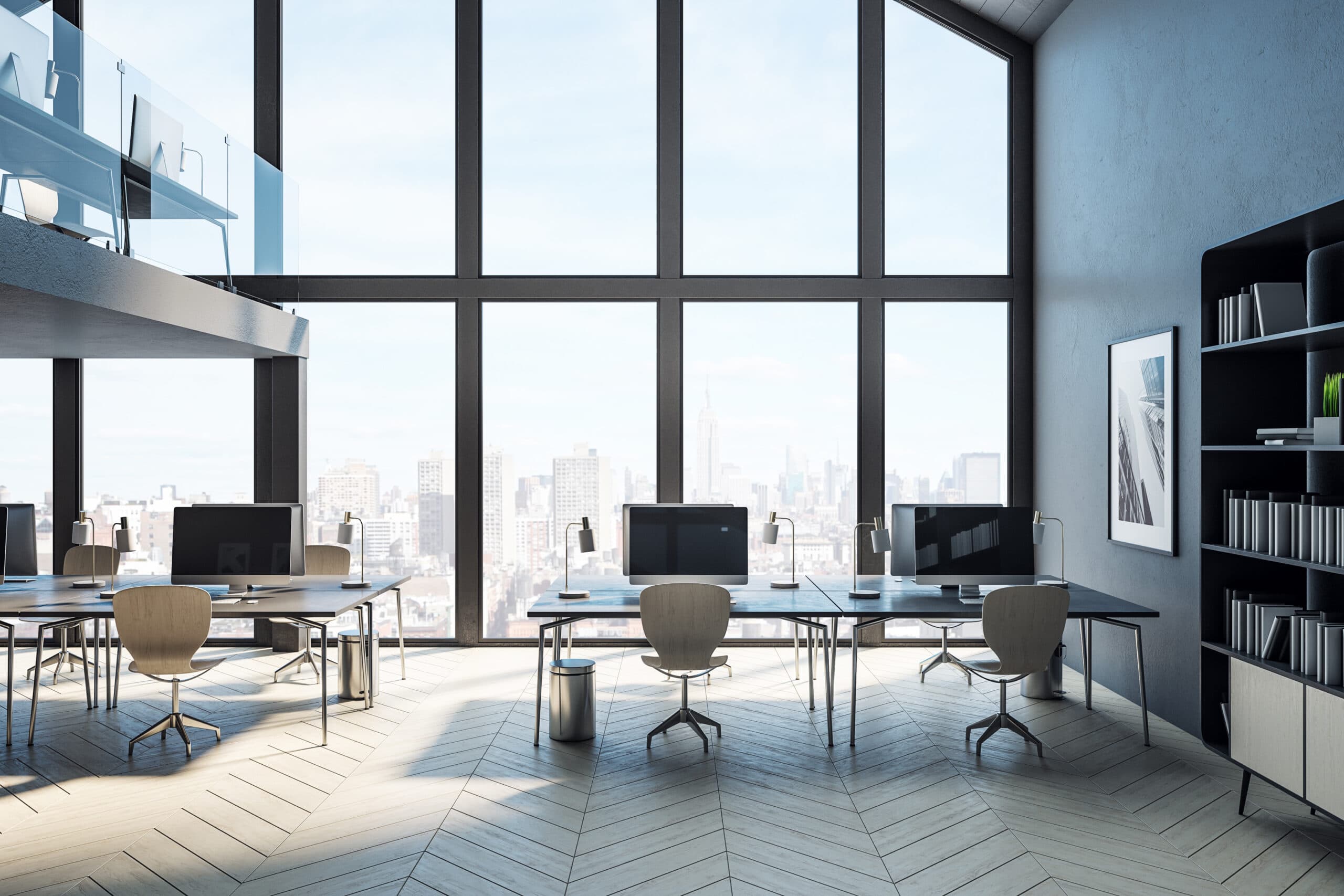 Modern open-plan office workspace with city skyline views and natural light