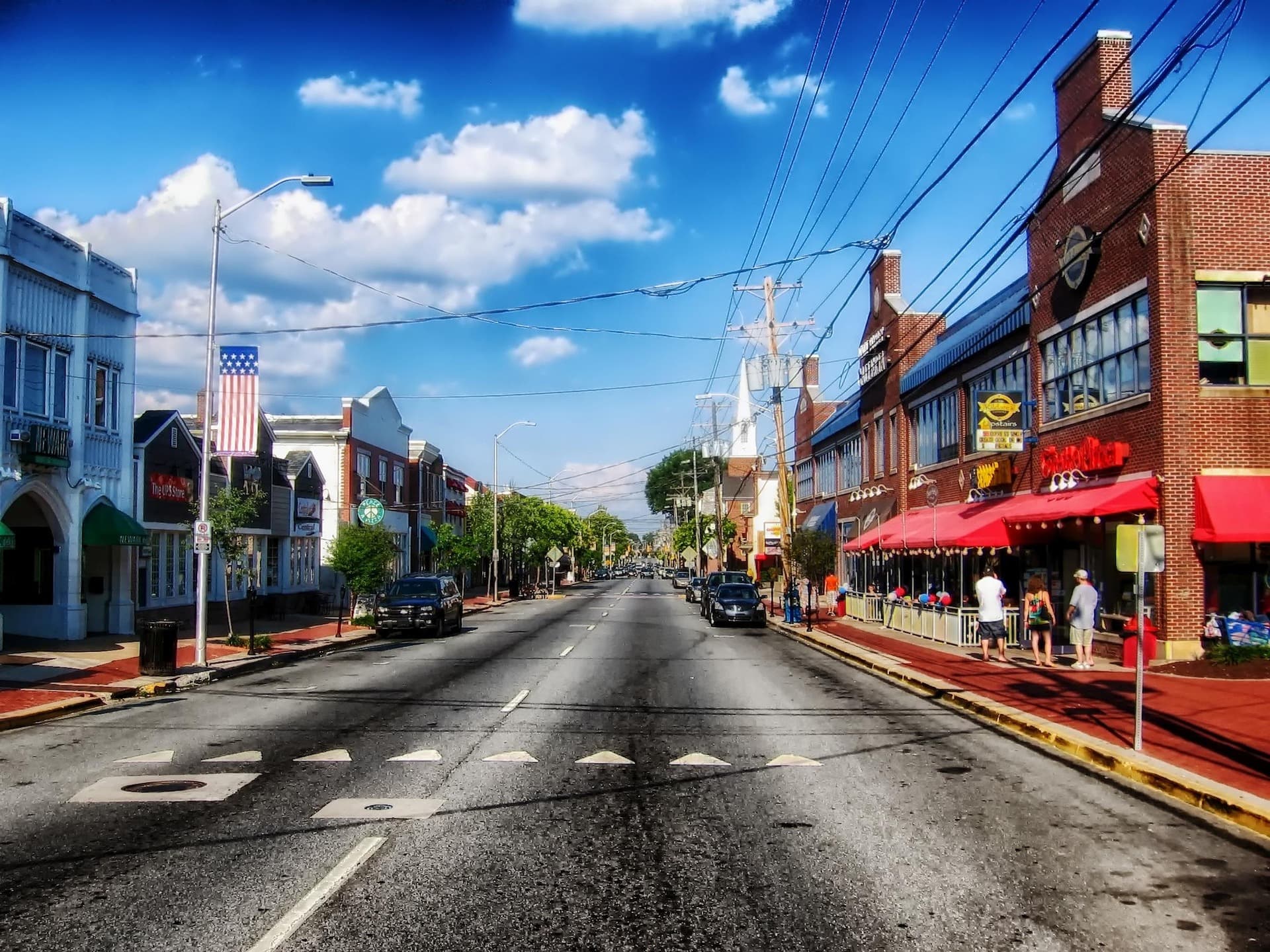 Main Street in Newark, Delaware with shops and restaurants on a sunny day